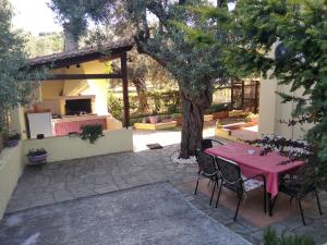 d'une terrasse avec une table et des chaises sous un arbre. dans l'établissement Apostolos, à Ágios Nikólaos