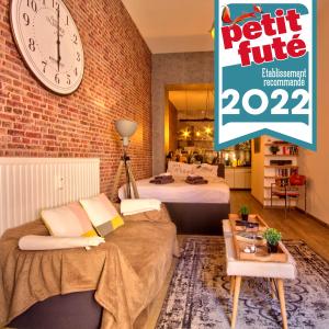 Habitación con 2 camas y reloj en la pared en New York Loft - Fully equipped and available long-term - Perfect location IN city center, en Namur