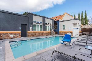 einen Pool mit einem blauen Stuhl neben einem Haus in der Unterkunft Best Western Inn Santa Clara in Santa Clara