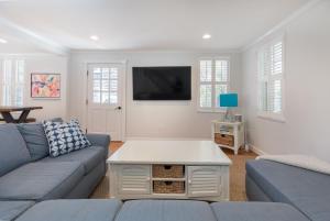 un salon avec un canapé bleu et une télévision dans l'établissement 45A Pleasant St, à Nantucket