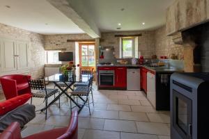 a kitchen with red appliances and a table and chairs at le Guimapé in Assay