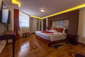 a bedroom with a large bed and a piano at Hotel Suites Teziutlan in Teziutlán +38 photos