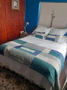 1 dormitorio con 1 cama con edredón azul y blanco en Hostal Boutique "Maryluz", en Coyhaique