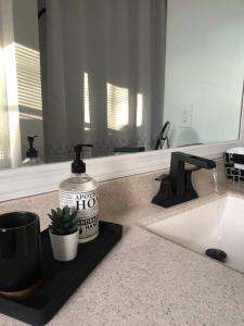 a bathroom counter with a bottle of mouthwash and a sink at Catskills Cottage with Lake View Book Now in Rock Hill