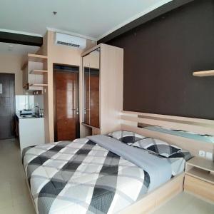 1 dormitorio con 1 cama grande y pared negra en High Livin Apartment Pasteur en Bandung
