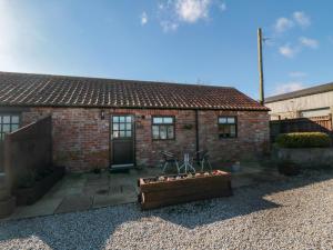 a small brick house with a patio in front of it at Blakey in Liverton