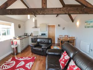 a living room with a leather couch and a kitchen at Freeborough in Liverton