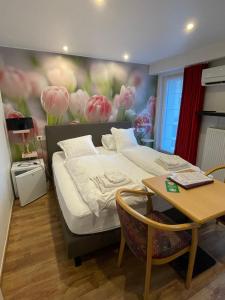 Schlafzimmer mit einem Bett mit Wandgemälde in der Unterkunft Hotel De Backer in Knokke-Heist