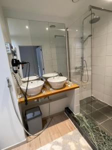 een badkamer met 2 wastafels en een douche bij Hotel De Backer in Knokke-Heist