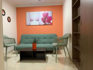 un soggiorno con un divano verde e 2 sedie di Apartamentos Laureles de la 70 a Medellín