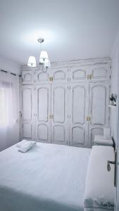 1 dormitorio con 1 cama blanca grande y 2 luces en Millan Astray, en Ceuta