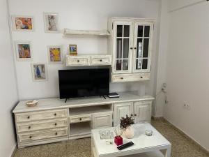 a white entertainment center with a television on top of it at Millan Astray in Ceuta +3 photos
