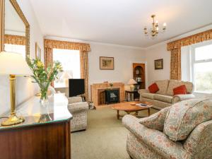 sala de estar con sofá y chimenea en The West Wing en Skye of Curr