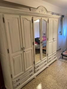 Armario blanco con espejo en la habitación en Millan Astray, en Ceuta