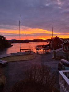 un tramonto su un corpo d'acqua con una barca a vela di VILLA BRATTHOLMEN a Brattholmen