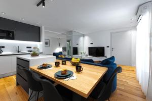 cocina y sala de estar con mesa de madera y sillas azules en Apartment Old Town Finesse, en Dubrovnik