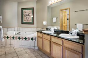a bathroom with two sinks and a bath tub at Grand Timber Lodge in Breckenridge