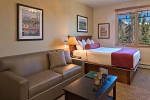 a hotel room with a bed and a couch at Grand Timber Lodge in Breckenridge