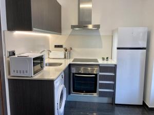 a small kitchen with a microwave and a refrigerator at Ca_LaGrava in Jávea