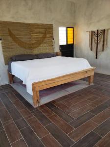una camera con un grande letto con struttura in legno di Casita Tonina a Ocosingo