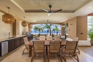 cocina abierta y comedor con mesa y sillas en Extravagant Beachfront Mansion in Flamingo, Second to None, en Playa Flamingo