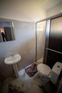 a bathroom with a toilet and a sink and a shower at Hotel Monte Carlo in Dourados