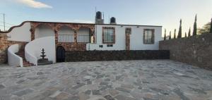 a house with a stone patio in front of it at Hotel Beraka in Bernal