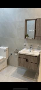 a bathroom with a sink and a toilet and a mirror at بيات للنزل السياحية in Al Qarāḩīn