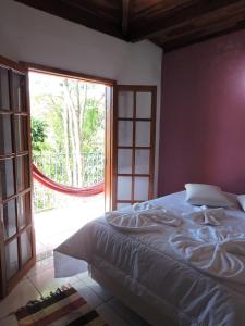 ein Schlafzimmer mit einem Bett und einem großen Fenster in der Unterkunft Pousada Vista Verde in Cunha