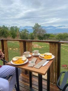 a table with two plates of food on a deck at Glamping Barichara in Barichara