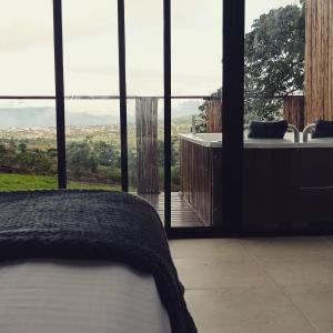 a bedroom with a bed and a view of a tub at Glamping Barichara in Barichara