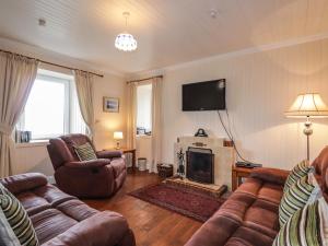 a living room with a couch and a fireplace at Bayview House in Fiskavaig