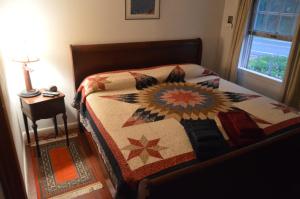 a bedroom with a bed with a quilt on it at Mount Harmony Farm Guest House in Sheffield