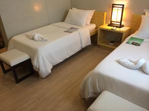 a hotel room with two beds and a lamp at Shore Time Hotel - Annex in Boracay +33 photos