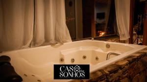 a bath tub in a bathroom with a sign on it at Casa dos Sonhos in Ibicoara