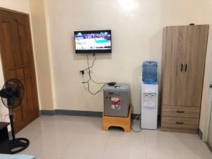 Cette chambre dispose d'une télévision murale et d'une machine. dans l'établissement Door 8 Bench Apartment, à Tacloban