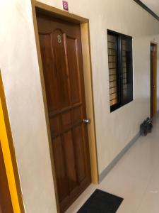 - une porte en bois dans une chambre avec un miroir dans l'établissement Door 8 Bench Apartment, à Tacloban