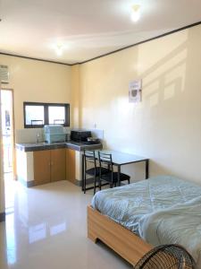 Cette chambre comprend un lit et une cuisine avec un bureau. dans l'établissement Door 8 Bench Apartment, à Tacloban
