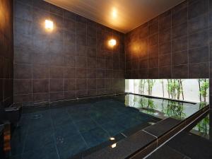 東京的住宿－新宿歌舞伎町超級酒店，一个带瓷砖墙的房间的游泳池