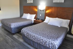 a hotel room with two beds in a room at Moonlight Inn and Suites Sudbury in Sudbury