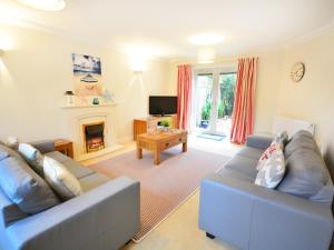 ein Wohnzimmer mit 2 blauen Sofas und einem Kamin in der Unterkunft Mariner's Rest in Weymouth