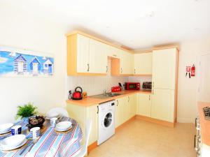 eine Küche mit einem Tisch und einer Waschmaschine in der Unterkunft Mariner's Rest in Weymouth + 7 Fotos