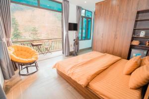 a bedroom with a large bed and a balcony at Story Villa Tam Đảo - Venuestay in Vĩnh Phúc
