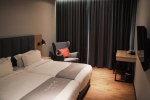 a hotel room with a bed and a chair at Amigo Hotel in Miri