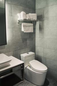 a bathroom with a toilet and a sink and towels at Amigo Hotel in Miri