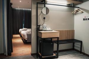 a room with a bed and a table with a mirror at Amigo Hotel in Miri