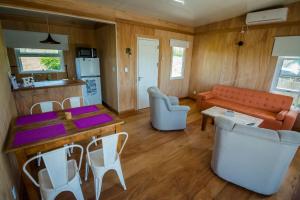 ein Wohnzimmer mit einem Tisch, Stühlen und einem Sofa in der Unterkunft Salvaje Punta in Nueva Palmira