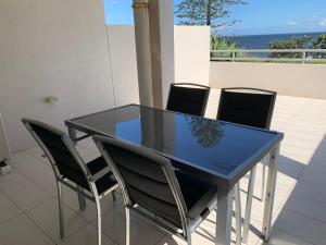 uma mesa azul e cadeiras com vista para o oceano em Kings Edge em Caloundra