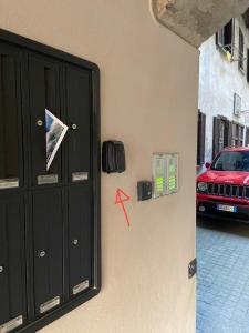 una puerta negra con un coche rojo en una calle en Un tocco provenzale a Savigliano, en Savigliano