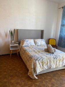 een slaapkamer met een bed en een tafel met een plant bij Casa Yolcatl in Mexico-Stad